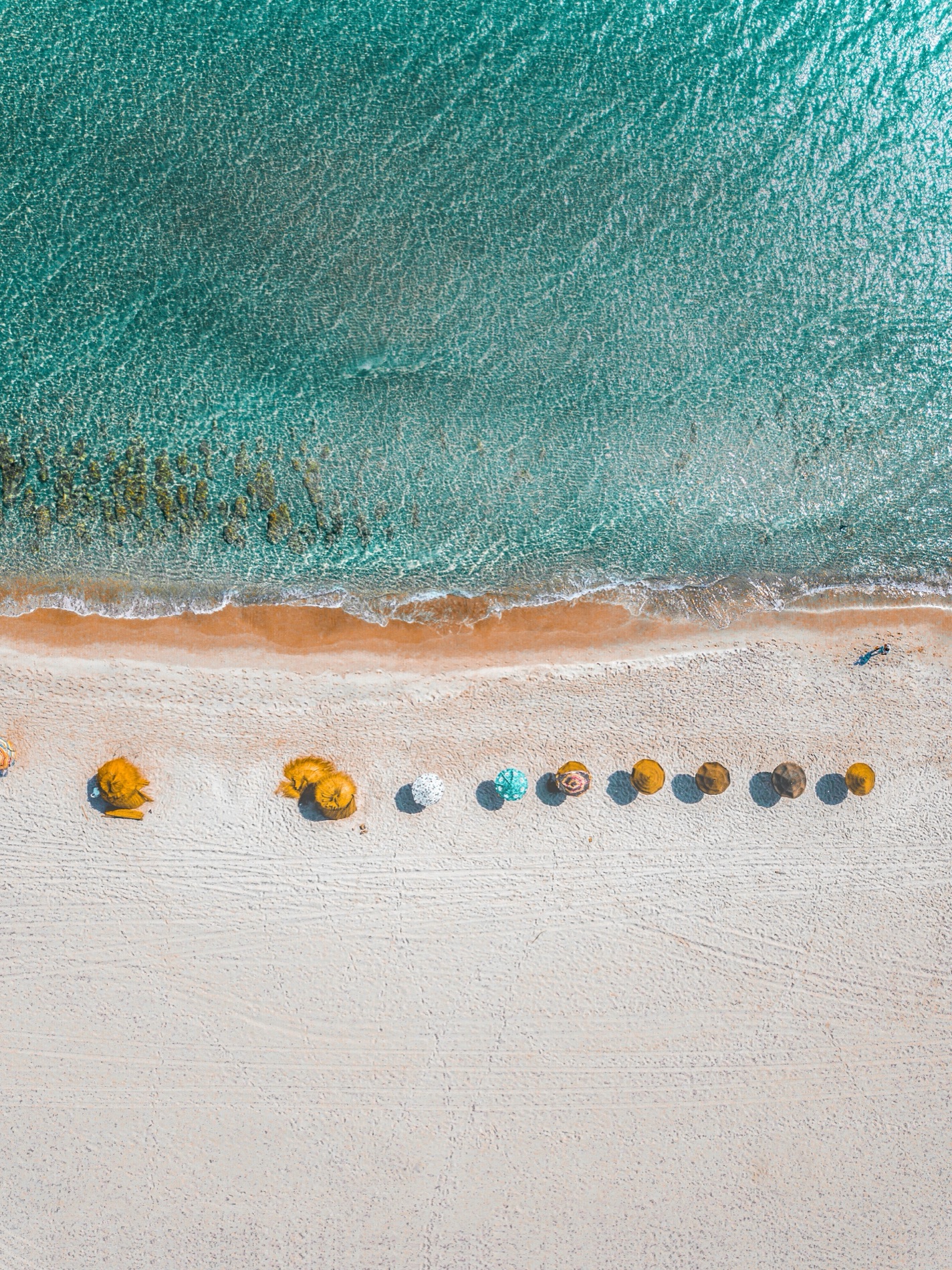A Cape beach from above, umbrellas along the waterline