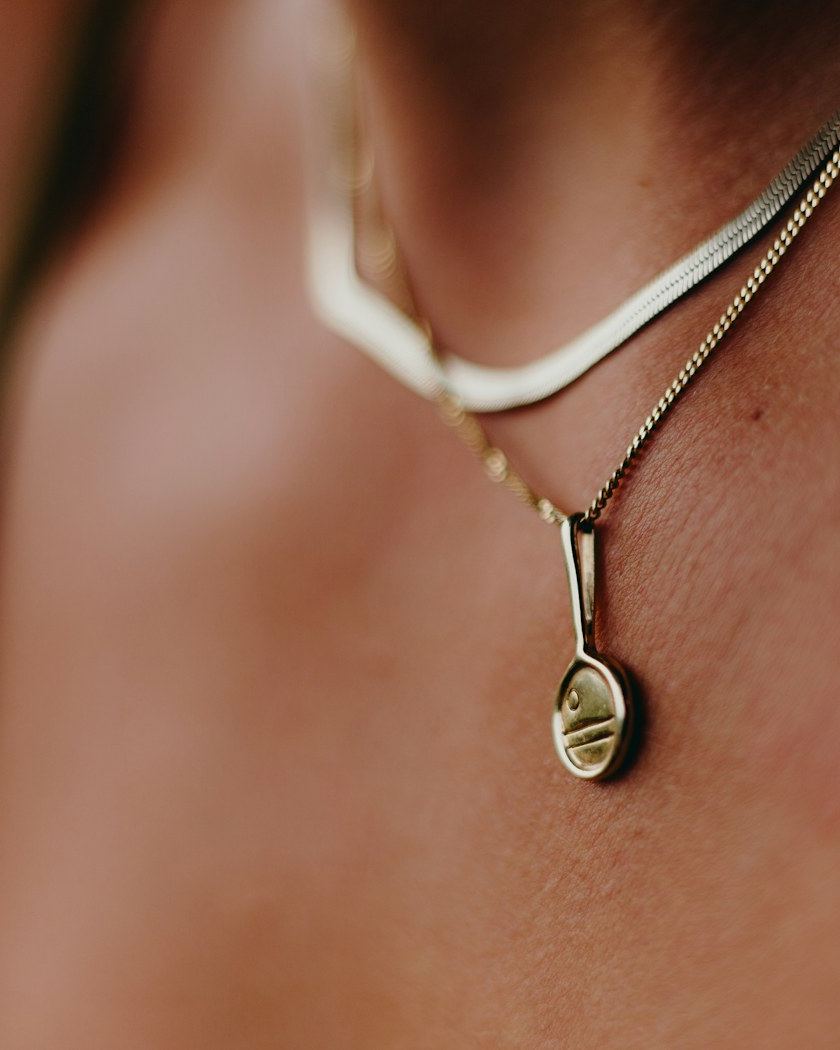 A fine gold chain worn against sun-warmed skin