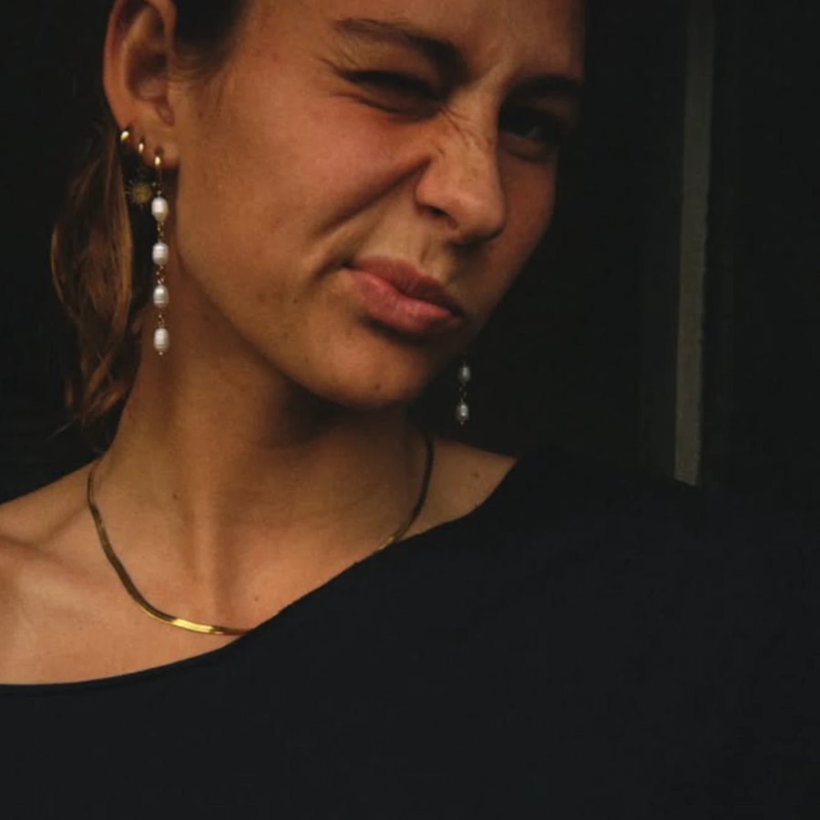 Jess, the founder of Salted Sol, wearing the herringbone chain and pearl drop earrings